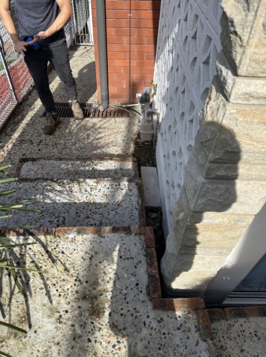 Excavation trench exposing old sewer pipes