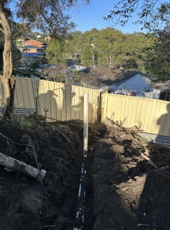 Old sewer pipe exposed in trench