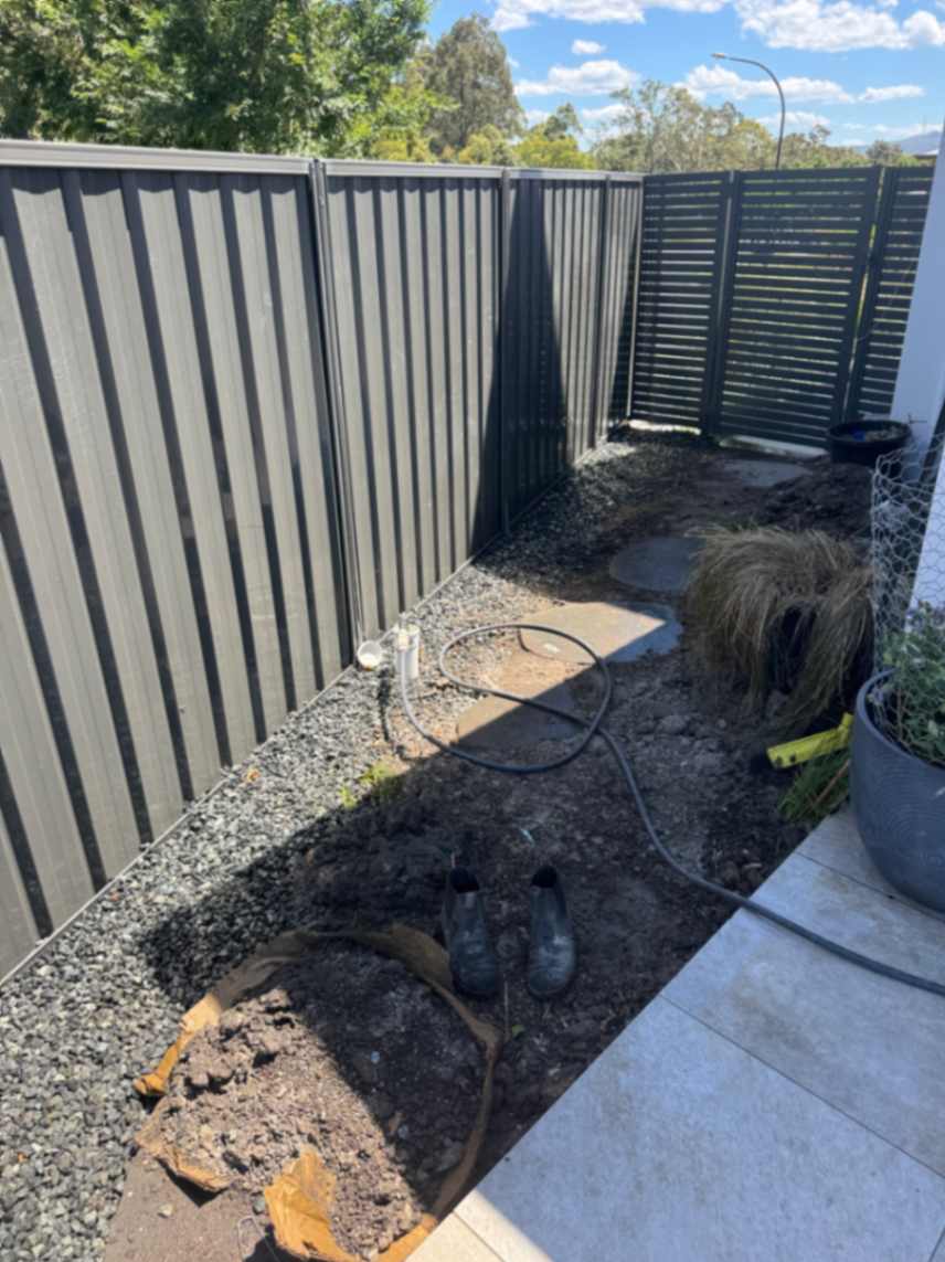 Garden bed under construction with dark fencing.