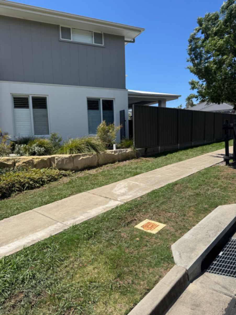 Backyard with stone retaining wall and lawn.