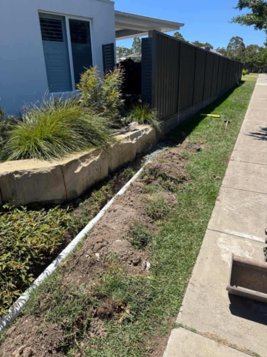 Front garden bed along dark fence line.