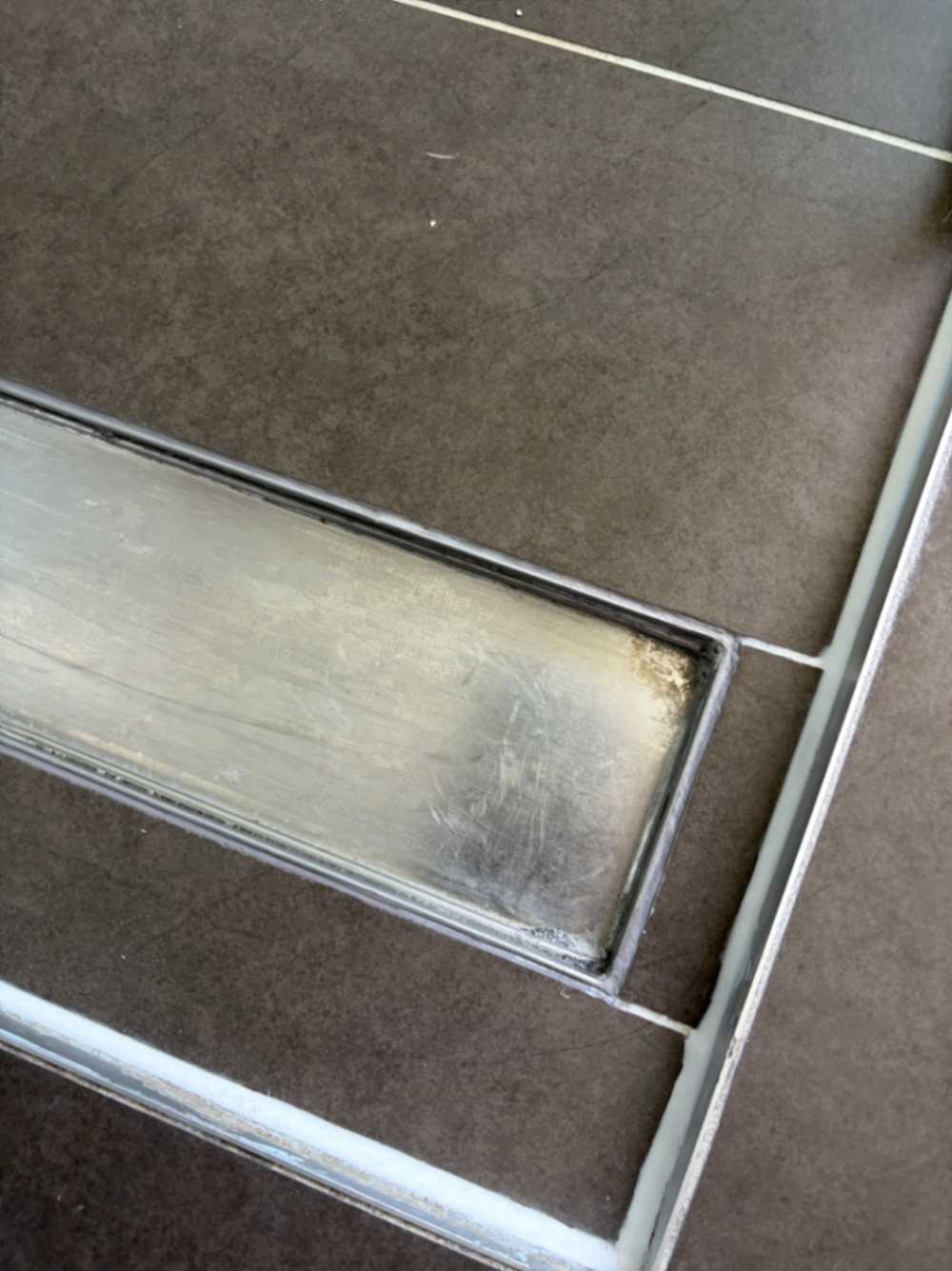 Shower base showing signs of water leakage before repair